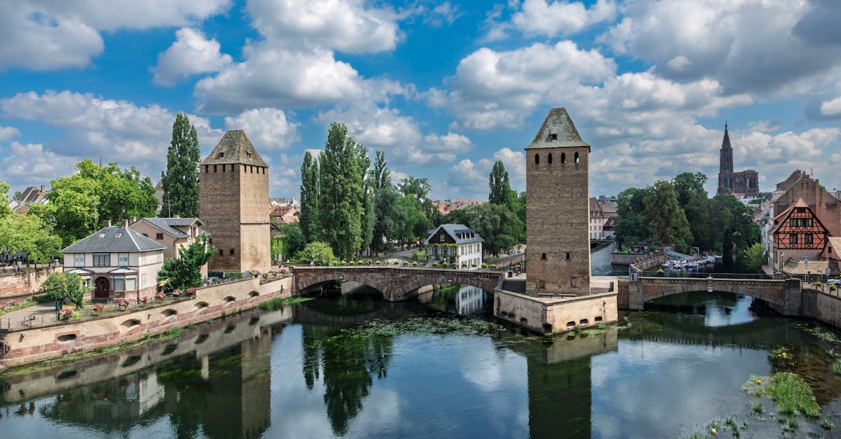 A scenic view of historic towers and bridges over the river in Strasbourg, France.