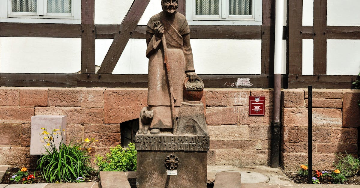 Stone statue of a historic figure outside a traditional German house in Stadtoldendorf.