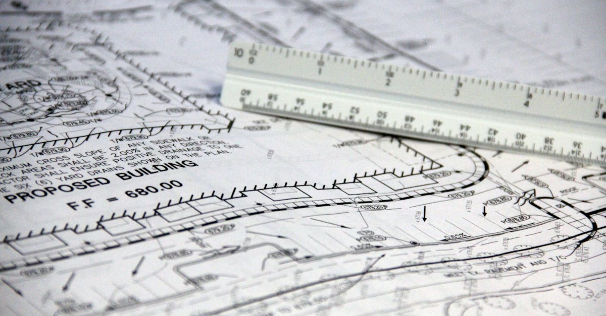 Detailed close-up of architectural blueprints with scale ruler, showing building plans and measurements.