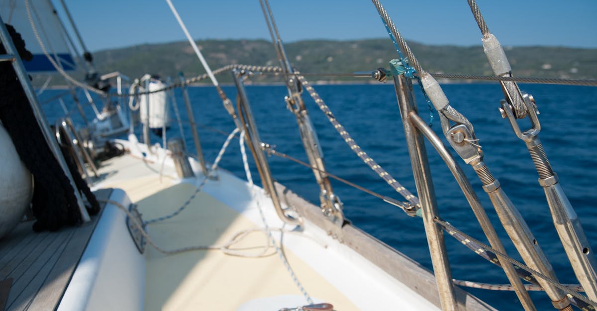 A close-up view of a sailboat deck with nautical ropes and rigging under blue skies.