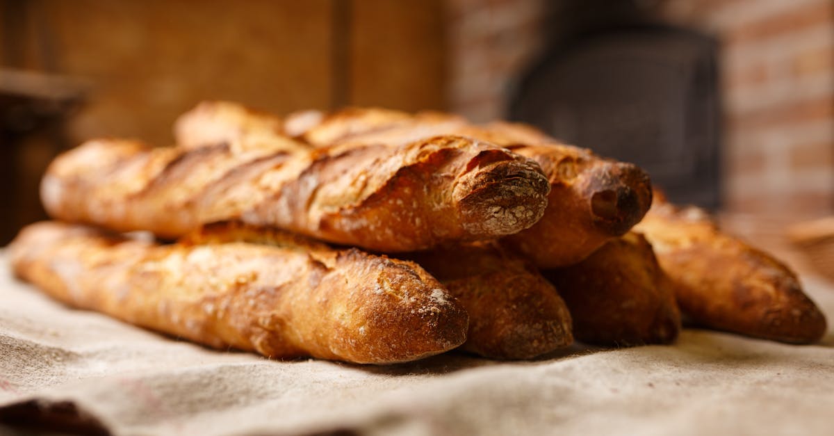 Warm, freshly baked rustic baguettes stacked in a cozy bakery setting.