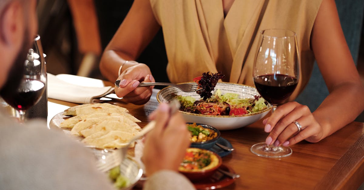 Couple enjoying a romantic dinner with wine and delicious meals at a cozy restaurant.