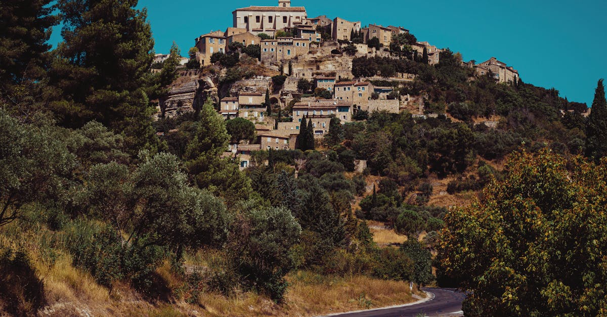 Low angle of empty narrow street leading to hill with medieval historical buildings and residential houses in Trevi on sunny day