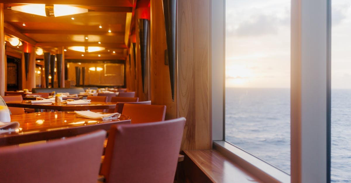 Elegant dining area on a luxury ship overlooking the ocean at sunset, perfect for relaxation.