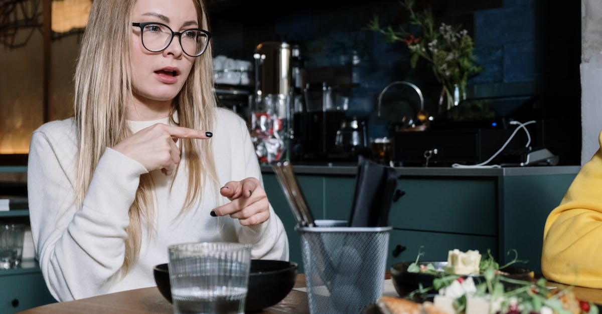 Woman using sign language while dining at a café, with focus on gesture communication.