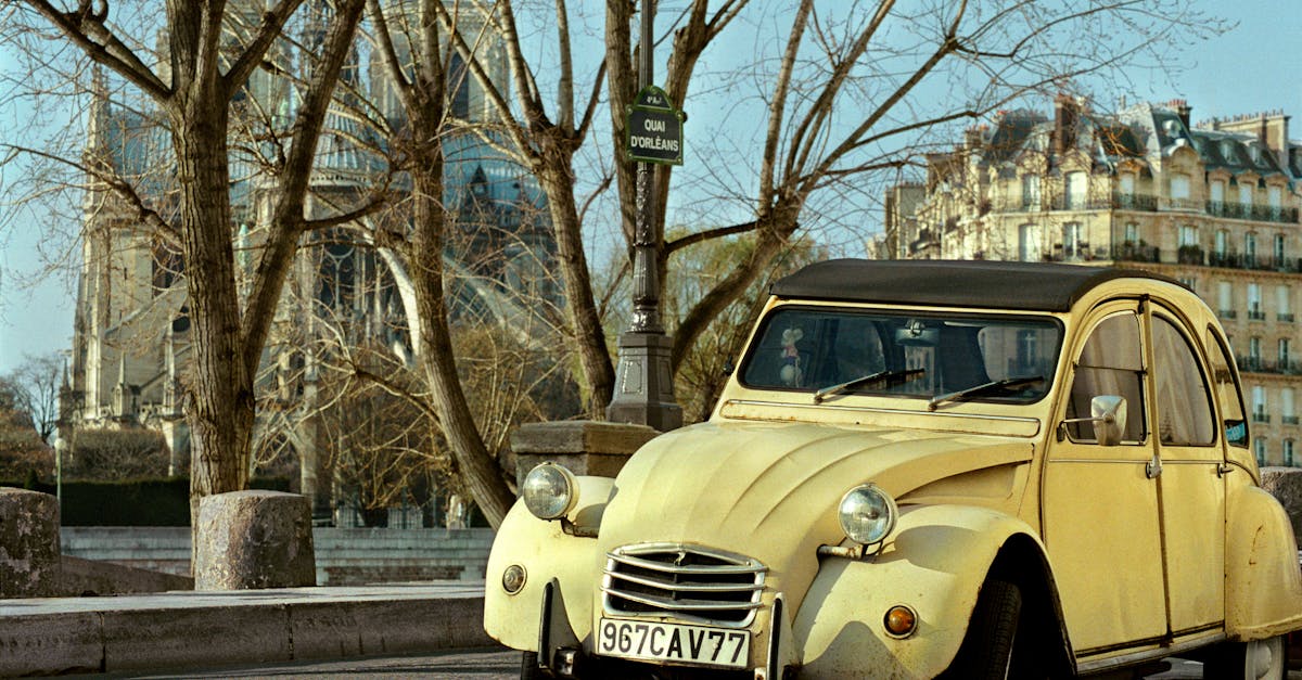 A classic Citroën 2CV car parked by Notre-Dame Cathedral in Paris.