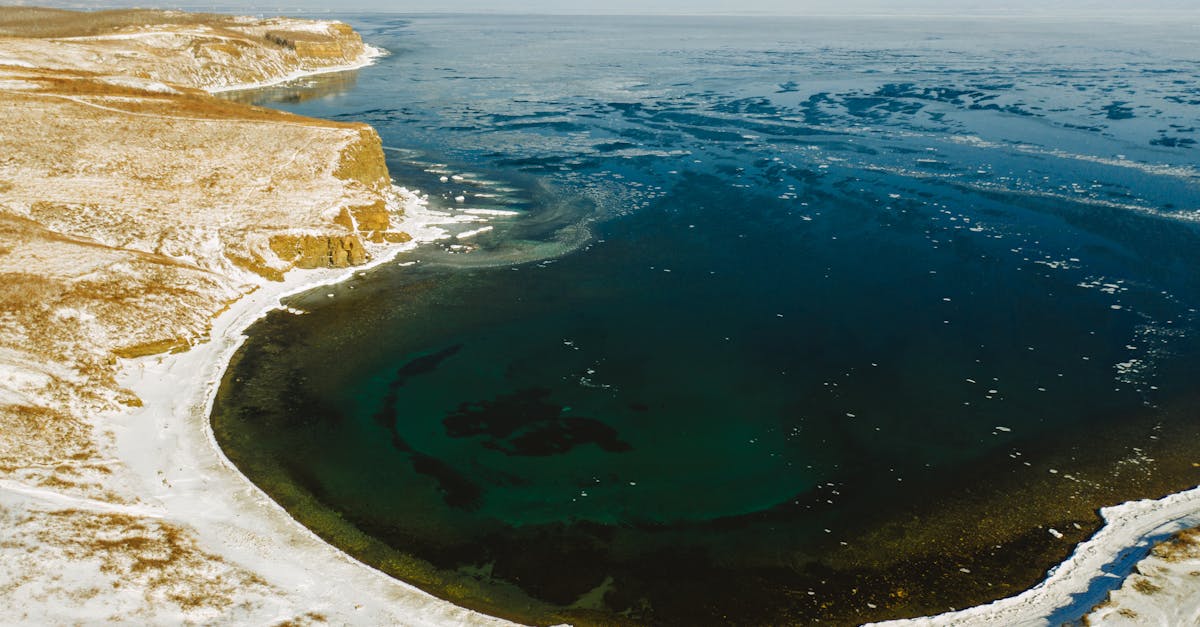 A breathtaking aerial view of a snow-covered coastline and frozen sea captured in winter.