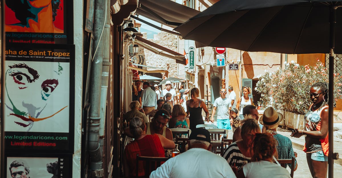 Lively street scene with people dining at an outdoor café in Saint-Tropez, France.