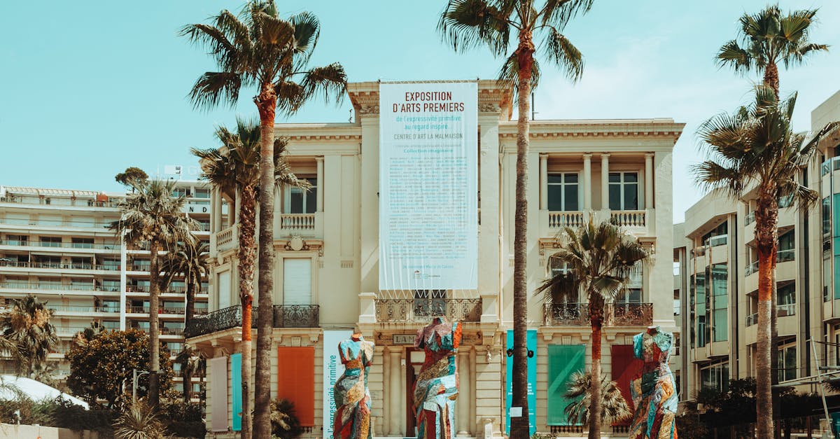 Art exposition building adorned with colorful statues and palm trees in a vibrant urban setting.