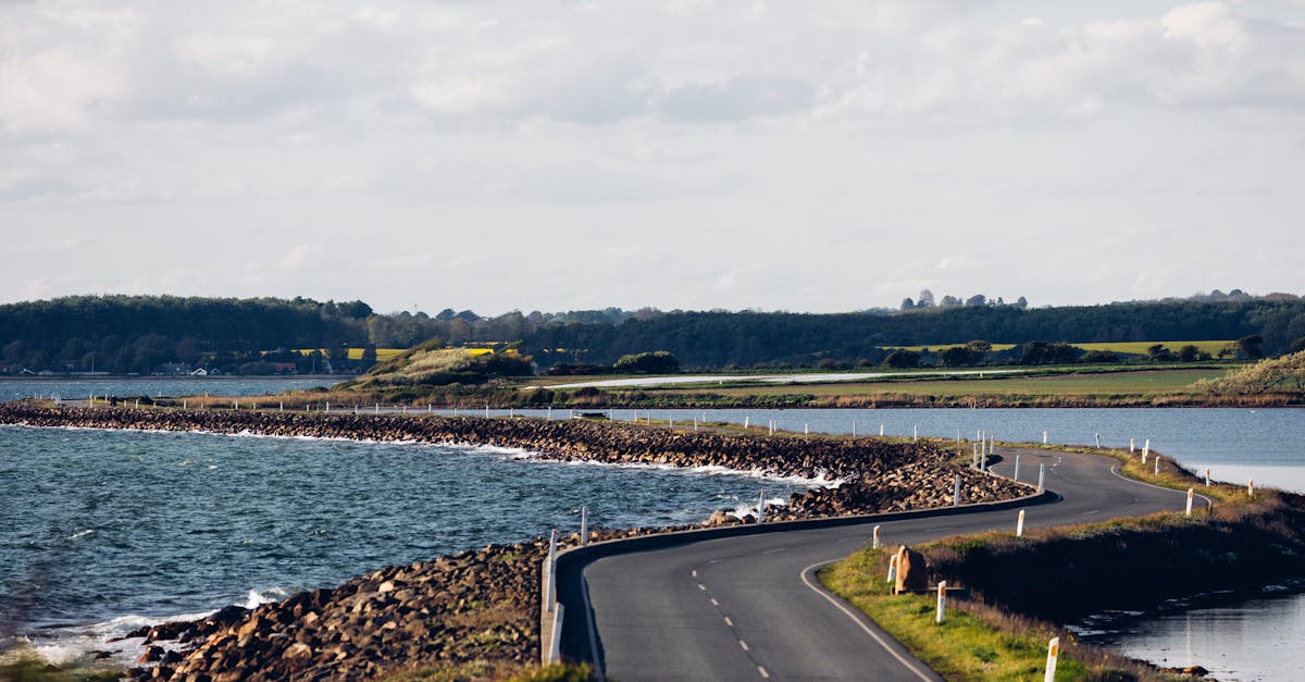 A picturesque winding road along the coast with expansive river and countryside views.