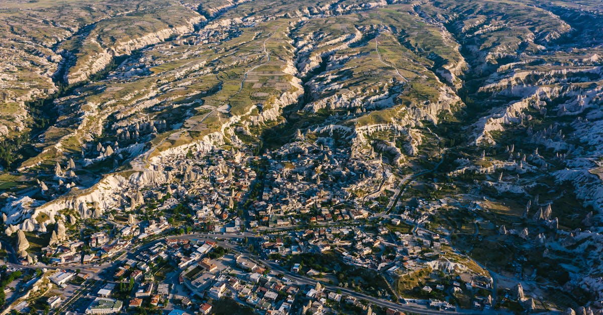 Stunning aerial view of Cappadocia's rocky landscape and towns during the day.