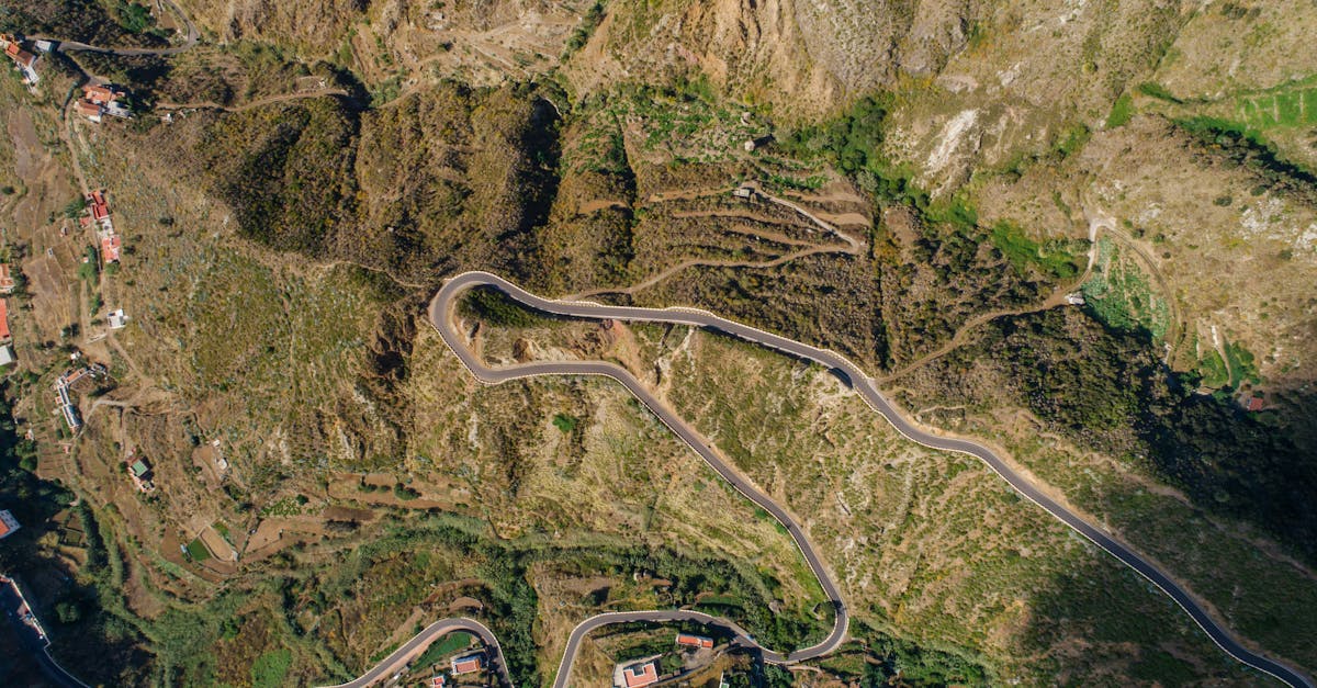 A stunning aerial view showcasing a winding road through a mountainous landscape.