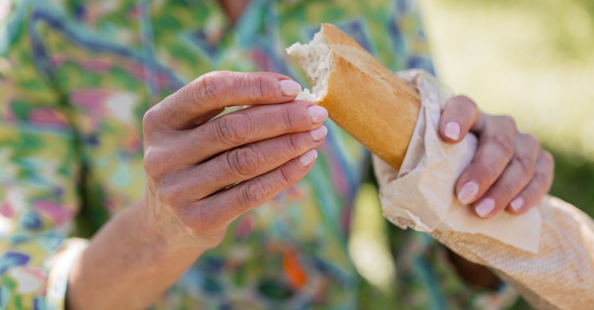 Close-up of hands holding a fresh baguette outdoors, perfect for lifestyle and food themes.