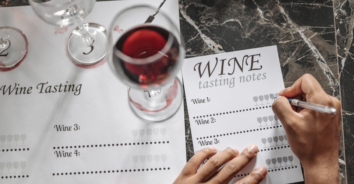 Close-up of wine tasting session with notes, glasses, and marble surface.