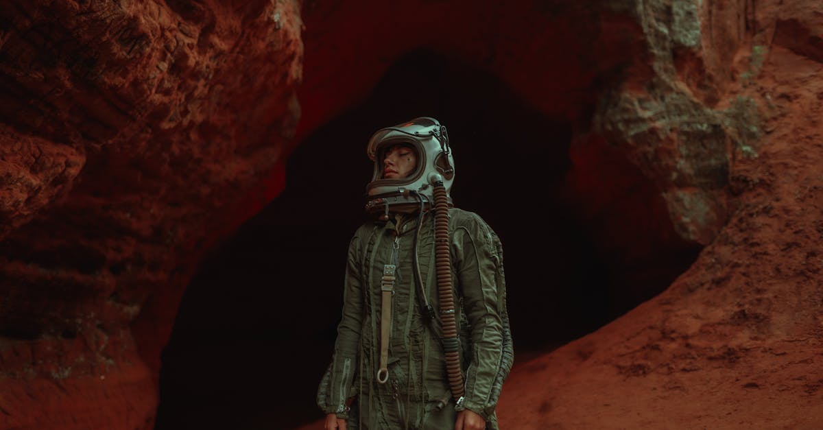 Astronaut in helmet explores a rugged, red-hued cave, exuding adventure and mystery.