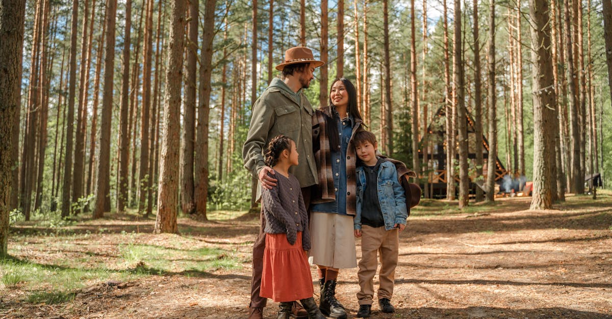 A family of four enjoys a peaceful vacation in a sunlit forest surrounded by tall pine trees.