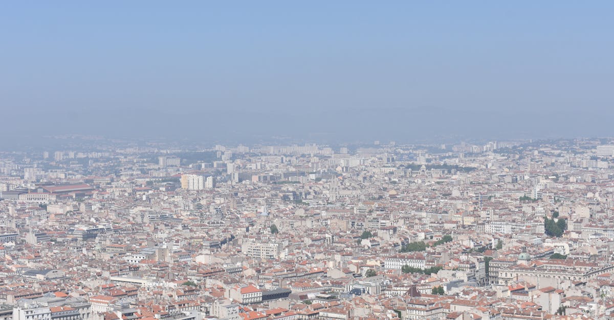 Aerial shot of Marseille, showcasing the city's sprawling urban landscape under a clear blue sky.